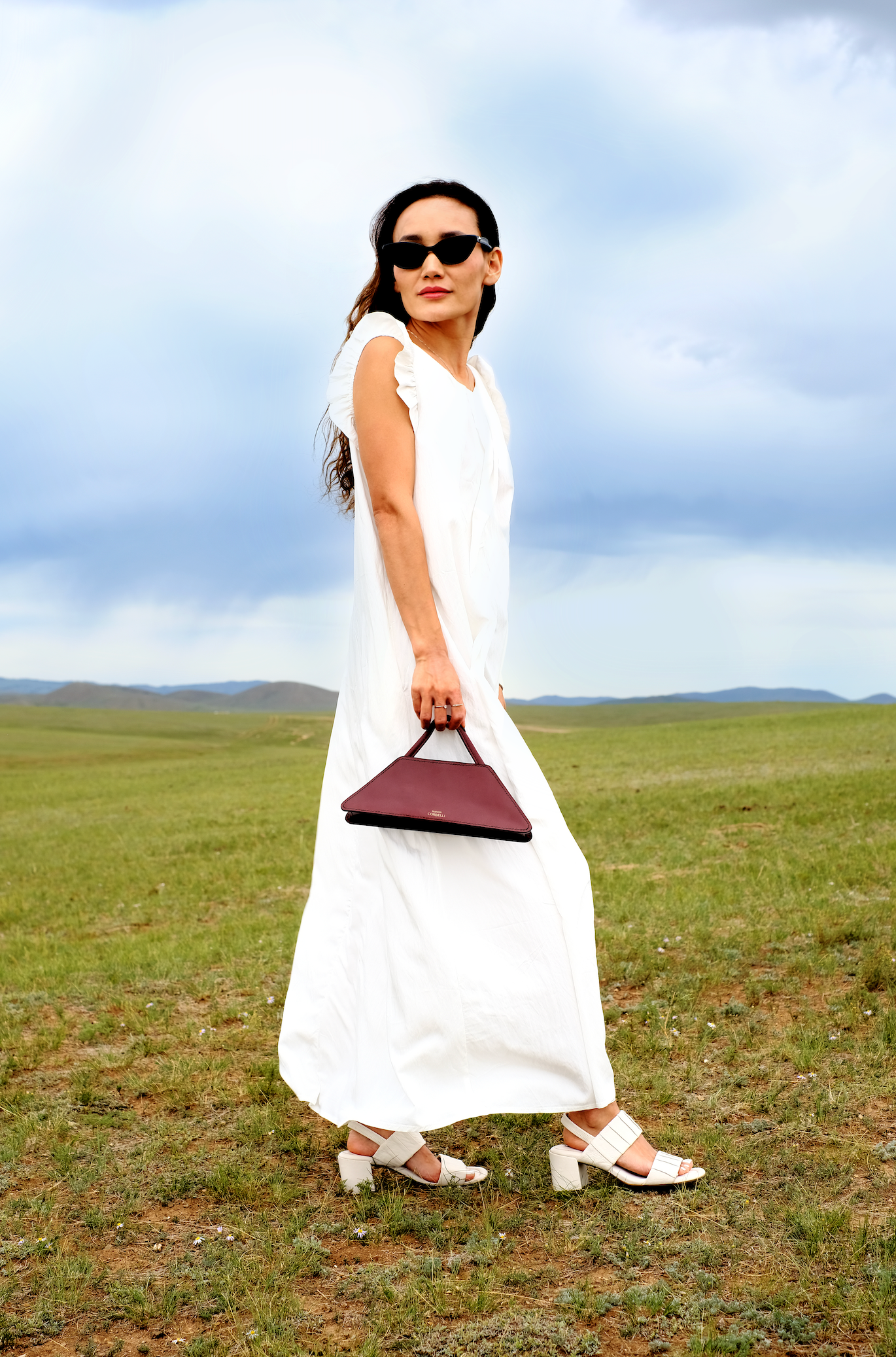 Elie mini bag, side view, Model, Field View, Burgundy, Clutch bag, Hand bag, mediterranean vibe, Premium leather, design, Woman model, leather, Unique design, Maison Corbelli, Luxury,
