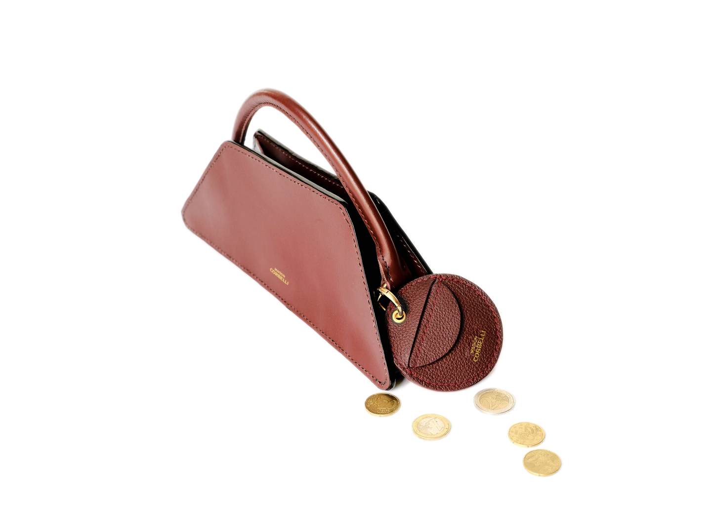 Oto, coin holder, gold-colored accessories, coin purse, Eli mini bag, purse, Hand bag, Clutch bag, few coins placed beside it, side view, hand Model, Studio, Burgundy, bag, mediterranean vibe, Premium leather, Unique design, Maison Corbelli, Luxury, grain calf leather