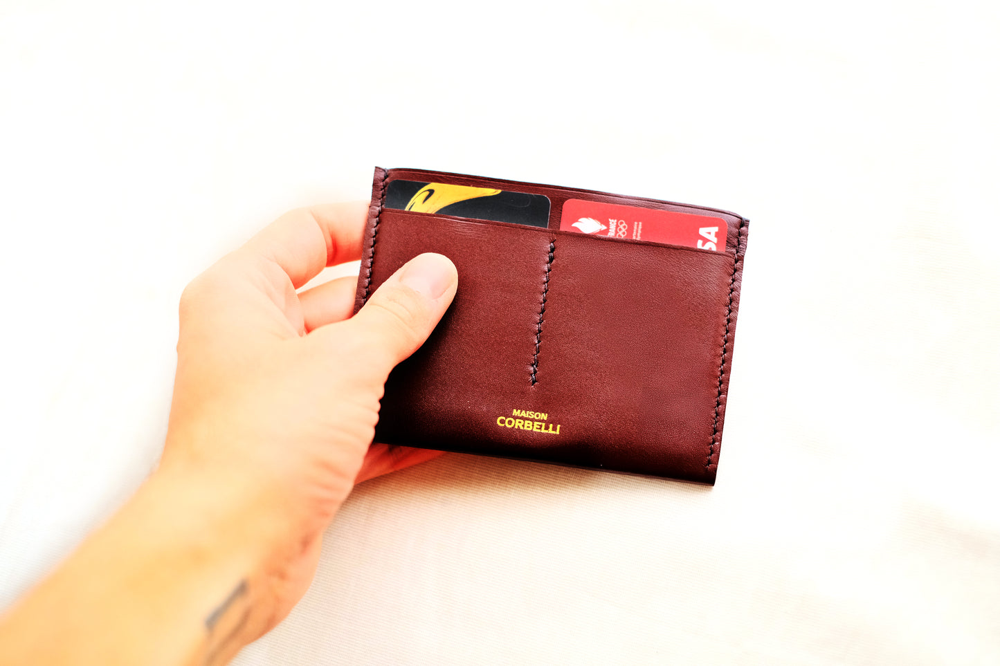 One wallet, cognac colour, on a white background, Wally wallet, top view, Pure leather, black colour, Passport size, studio photo, Close up open, hold in a hand