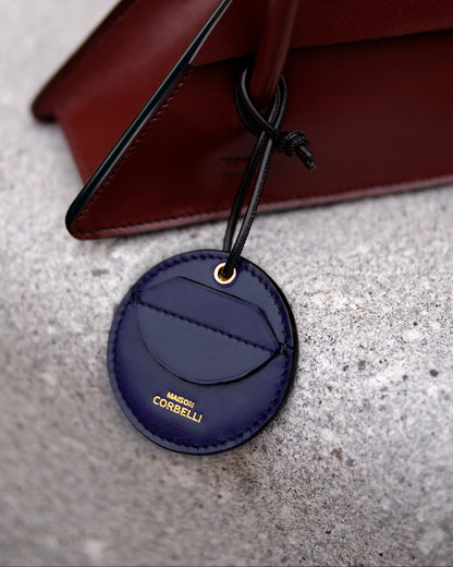 Oto, coin holder, gold-colored accessories, coin purse, few coins placed beside it, Front view, Model, Studio, Blue, bag, mediterranean vibe, Premium leather, Unique design, on a stone bench, Elie bag
