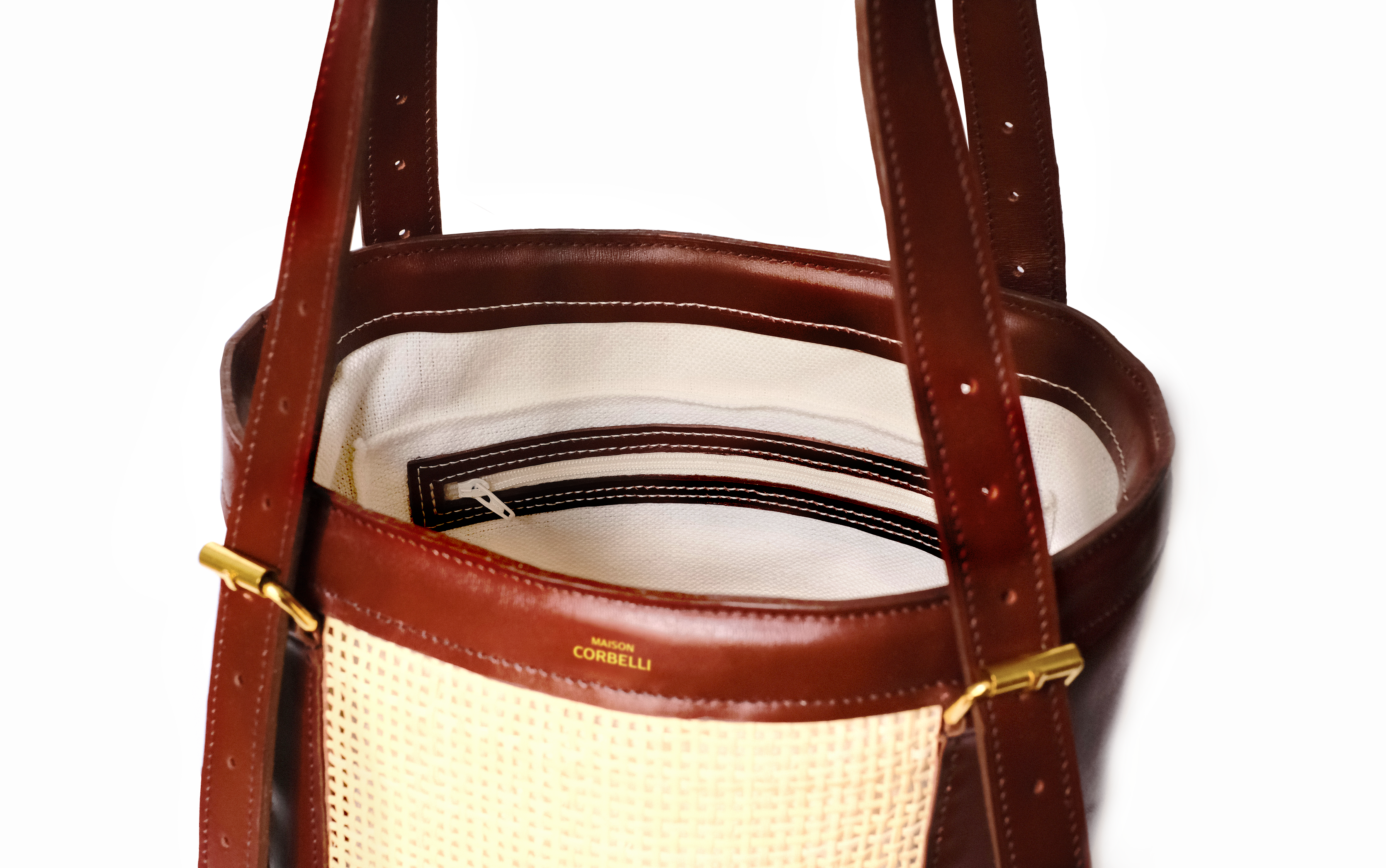 Alma bag, inside view, Detail pocket, Model, Studio, Burgundy, bucket bag, Hand bag, Rattan, mediterranean vibe, Premium leather, Unique design, Maison Corbelli, Luxury, grain calf leather, Alma Italian calf leather and rattan bucket bag, unique summer style, Close-up of the natural woven rattan and grain calf leather handle on the Alma bag, Model carrying the Alma rattan luxury summer bucket bag