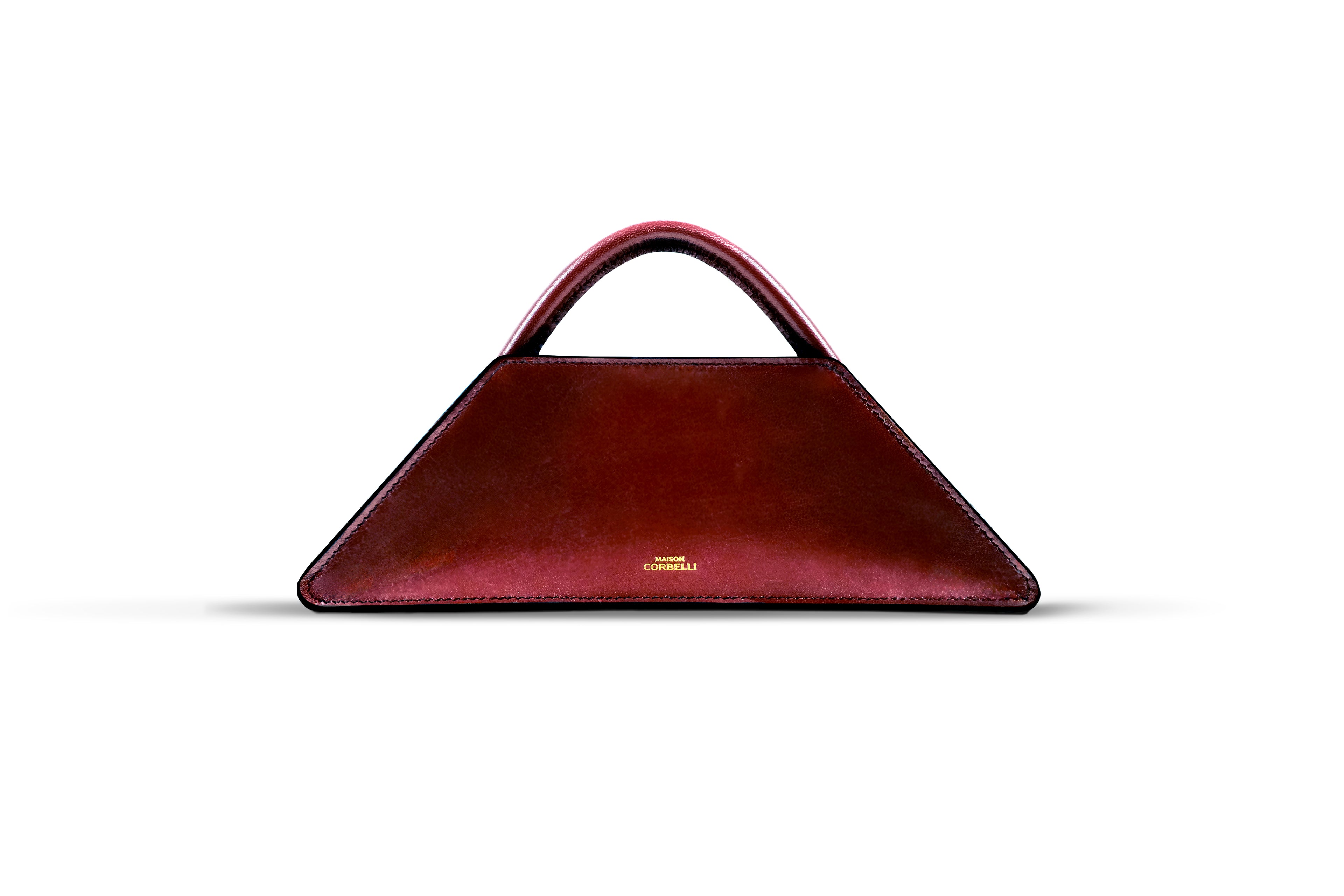 Maison Corbelli Elie Mini handhand in a burgundy colour front view standing in a studio with white background and sharp light. Golden logo with premium calf leather and a luxury look. Architectural look and mediteraneen vibes. Burgundy red Elie Mini Spanish calf leather crossbody bag, structured design, Model wearing the Elie Mini structured leather shoulder bag in Red for lifestyle, Close-up of the gold-toned hardware and calfskin leather texture on the Elie Mini