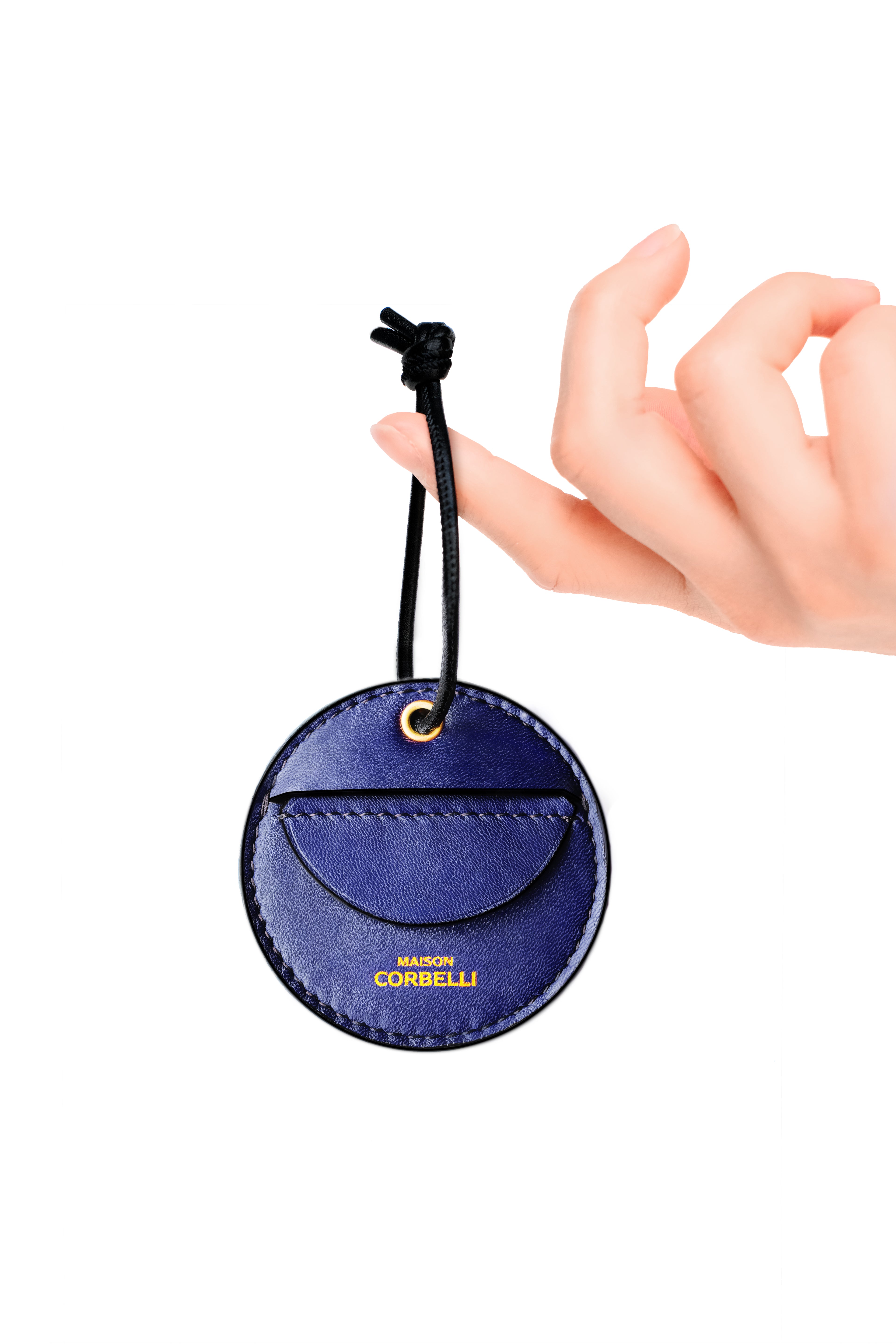 Round leather coin holder from Maison Corbelli with a hand holding it on a white background, Oto, coin holder, Navy blue, Blue, dark blue, gift for christmas, present, gold-colored accessories, coin purse, a finger holds it, Front view, Model, Studio, Burgundy, bag, mediterranean vibe, Premium leather, Unique design