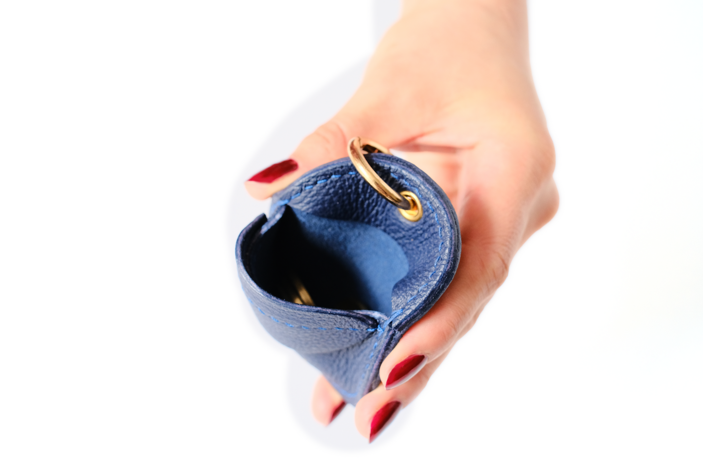 Oto, coin holder, gold-colored accessories, coin purse, few coins placed in it, top view, hand Model, Studio, Blue, bag, mediterranean vibe, Premium leather, Unique design, Maison Corbelli, Luxury, grain calf leather